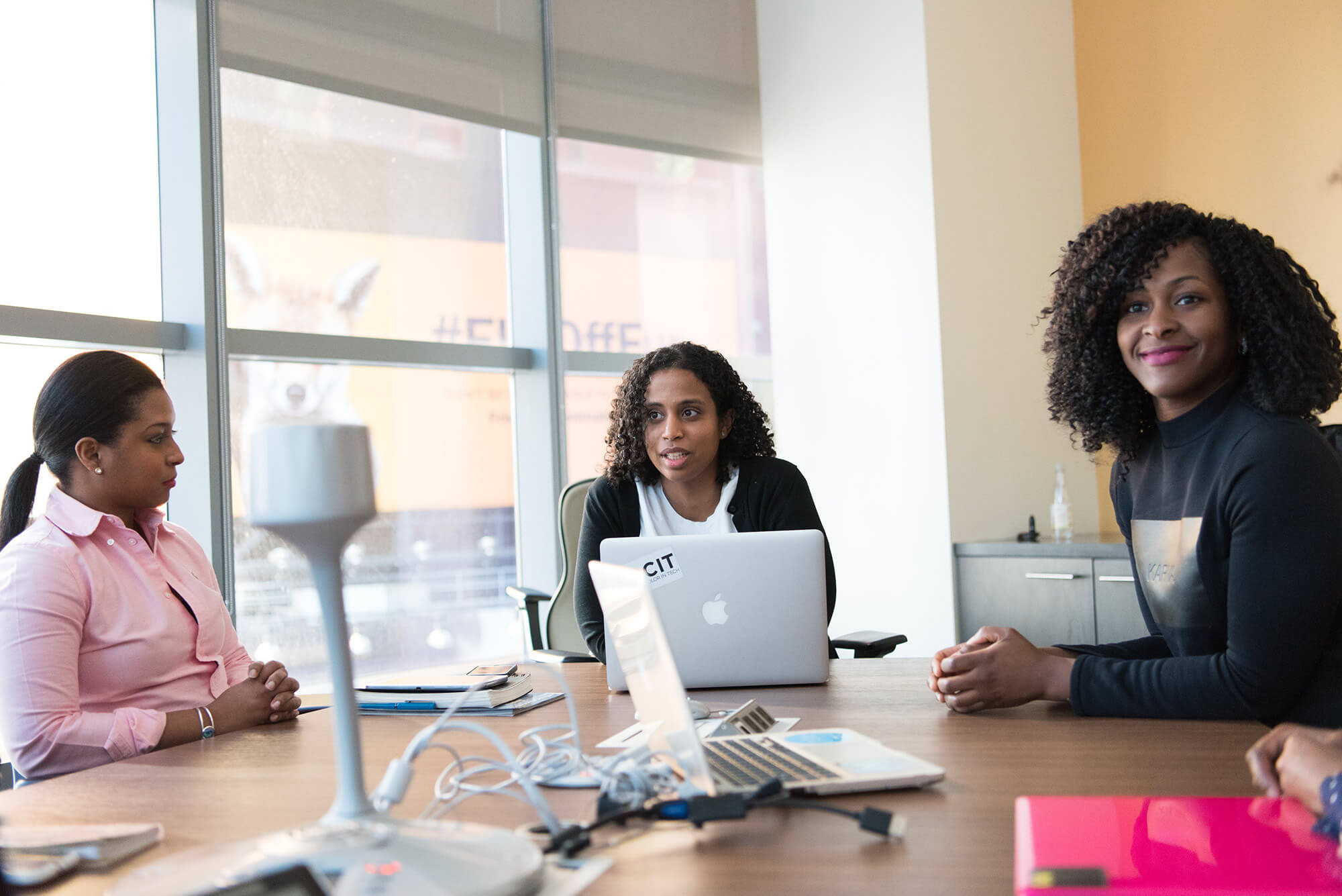 Three professional women sitting in a conference room