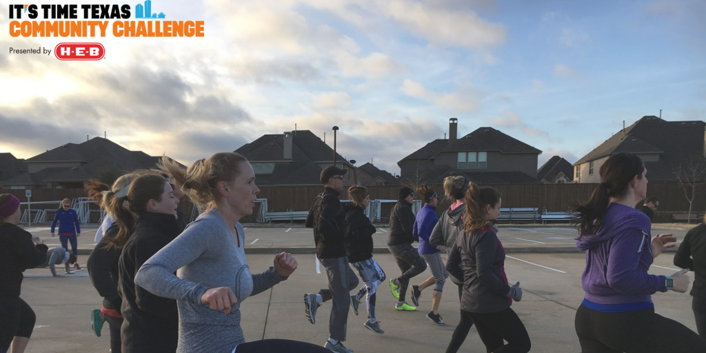 A group of people running and picking their knees up high in the early morning in their healthy community.