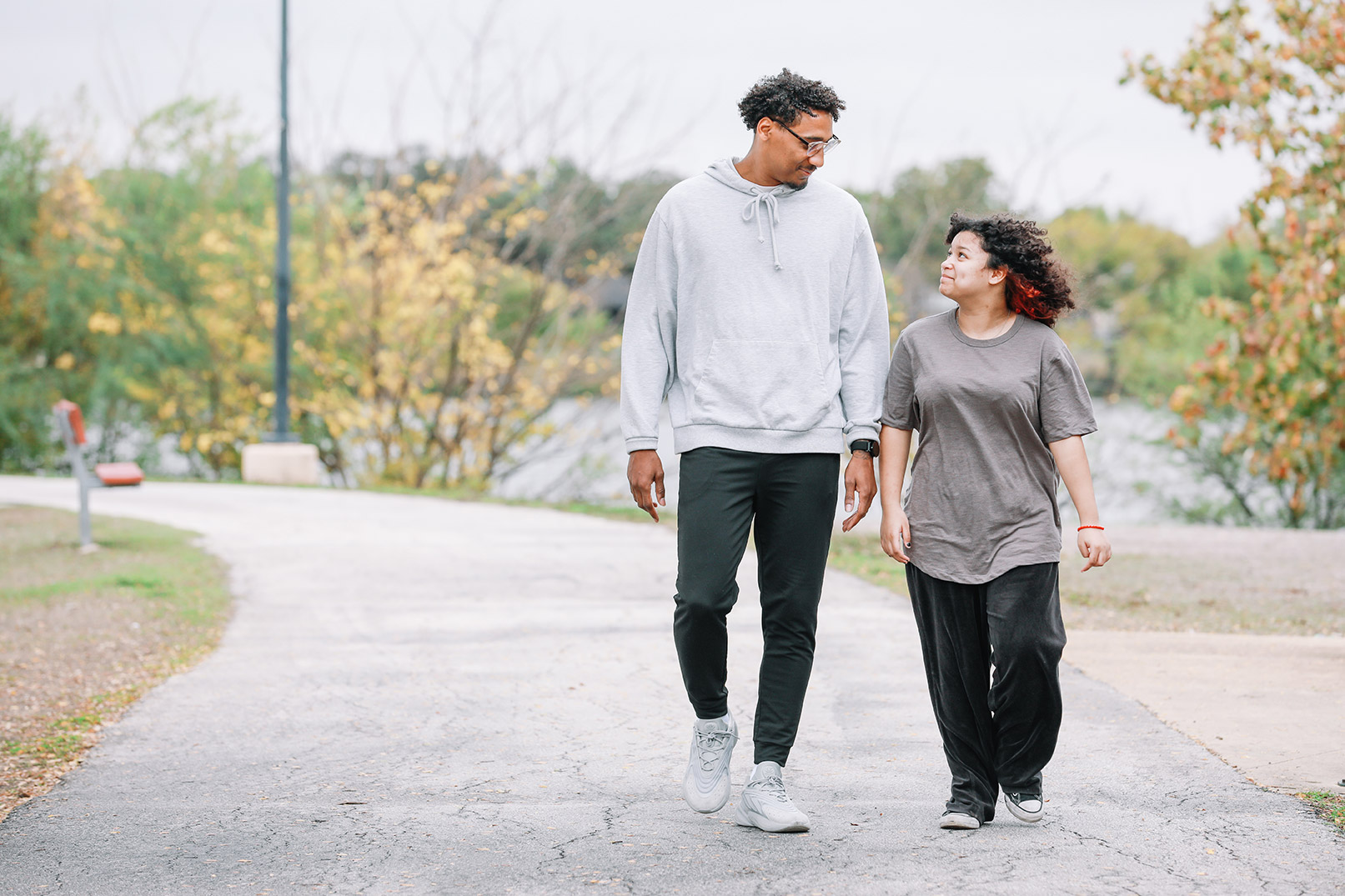 Father and daughter walking on a track in a park